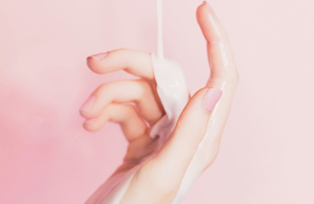 Weiße Creme läuft über eine Hand
