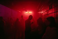 Eine Menschenmenge ist bei rotem Licht im Club zu sehen